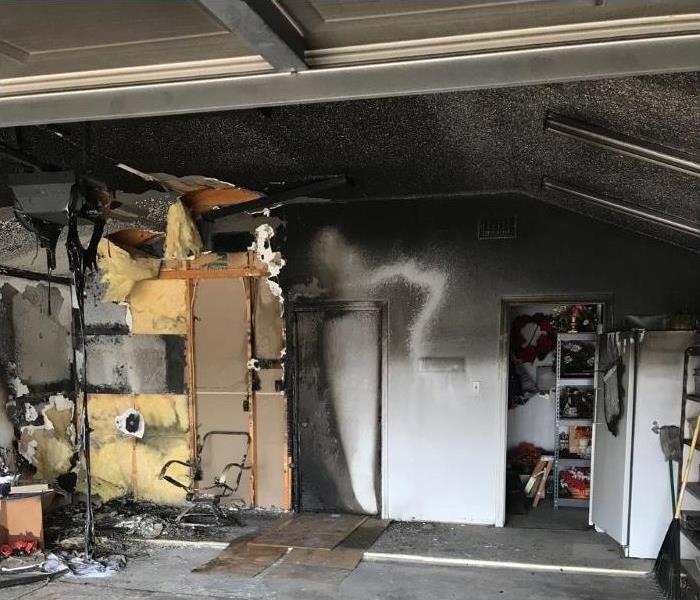 Large garage fire leave whole wall and ceiling black.
